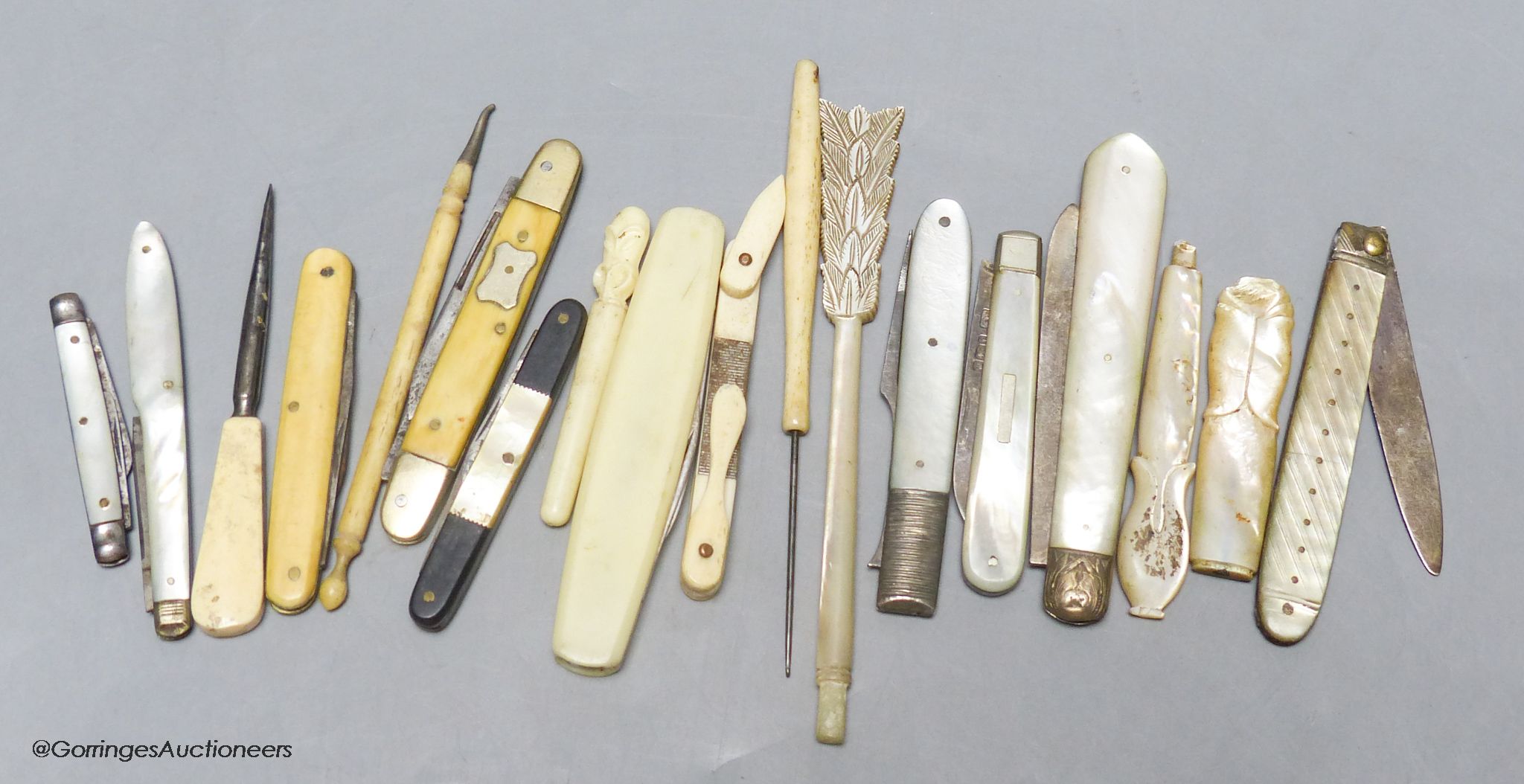 A group of silver and steel bladed pocket folding knives and a fork