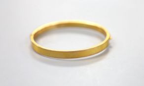 A George V 9ct gold hinged bangle, with engraved initials, 9.1 grams.