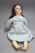 An A M 390 Bisque head doll, stamped AM, 55cm high.