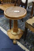 A William IV walnut and bird's eye maple caned seated adjustable music stool, height 54cm