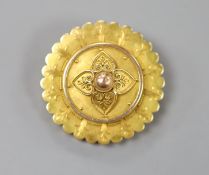 A Victorian yellow metal circular brooch, with central foliate motif, 38mm, gross 13.5 grams.