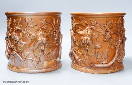 A pair of early 19th century salt glazed stoneware cylindrical pots, relief moulded with grapes and