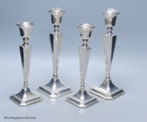 Two graduating pairs of George V silver candlesticks, James Deakin & Sons, Chester, 1925, weighted,