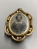 A Victorian pinchbeck and enamel revolving oval mourning pendant brooch, with plaited hair below a