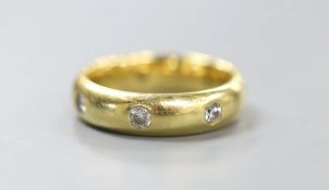 A modern 18ct gold and seven stone diamond gypsy set band, size M, gross 7.6 grams.