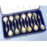 A 19th century cased set of twelve Italian? gilt white metal spoons, with figural and dolphin stem
