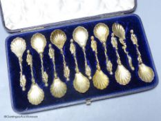 A 19th century cased set of twelve Italian? gilt white metal spoons, with figural and dolphin stem