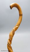 A carved wood walking stick in the style of a narwal tusk, length 85cm