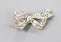 A 1920's/1930's white metal and diamond set bow brooch, 32mm, gross weight 4.5 grams.