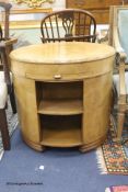 An Art Deco circular maple and bird's eye maple centre table, fitted slides over open shelves,