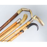 Five various walking sticks: three horn-handled, one silver-mounted and the other antler