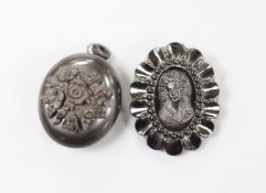 A jet oval pendant, carved with a bunch of flowers, 41mm and a similar brooch, carved with the bust