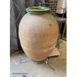 A large antique Italian oil jar, on iron stand with ceramic liner, height 144cm