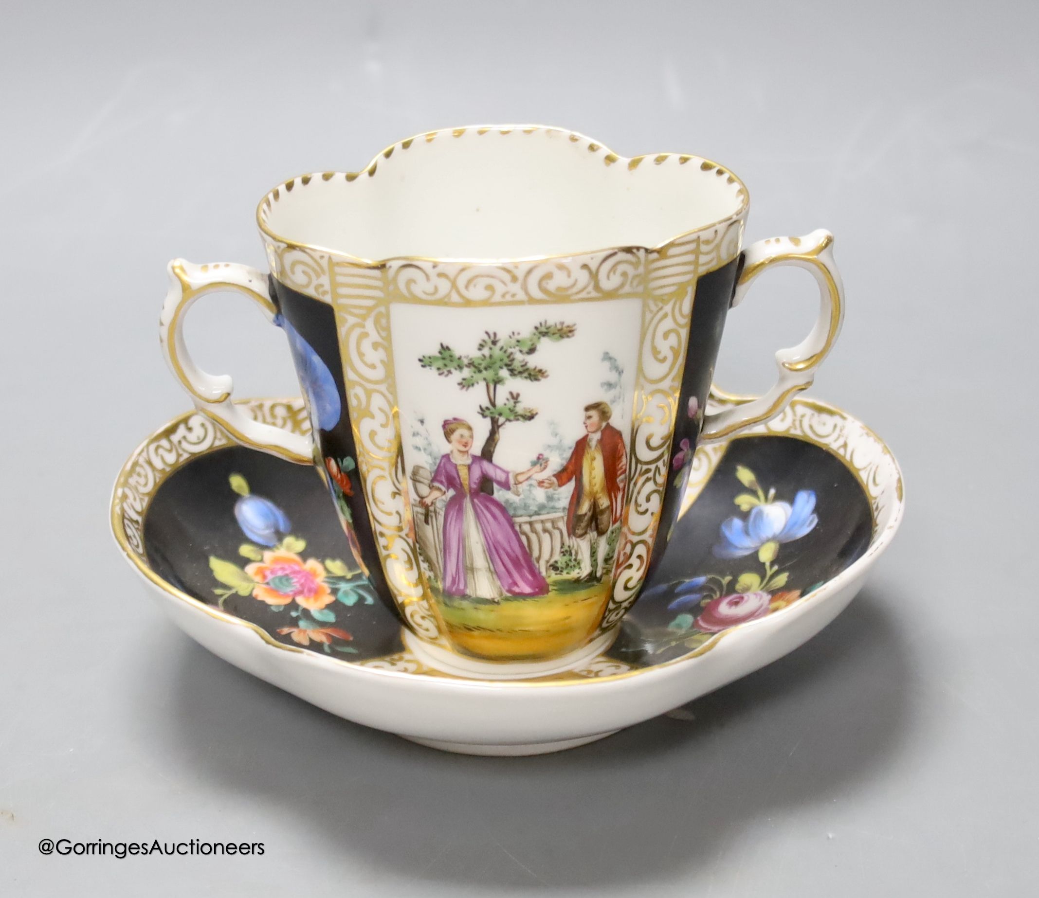 A Dresden two handled cup and saucer, height 8.5cm