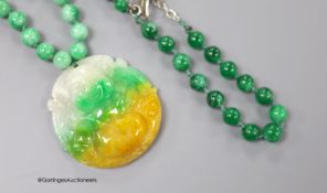 A jade pendant, carved as a Buddha, 50mmm, on a jade bead necklace, 50cm, together with a jade bead