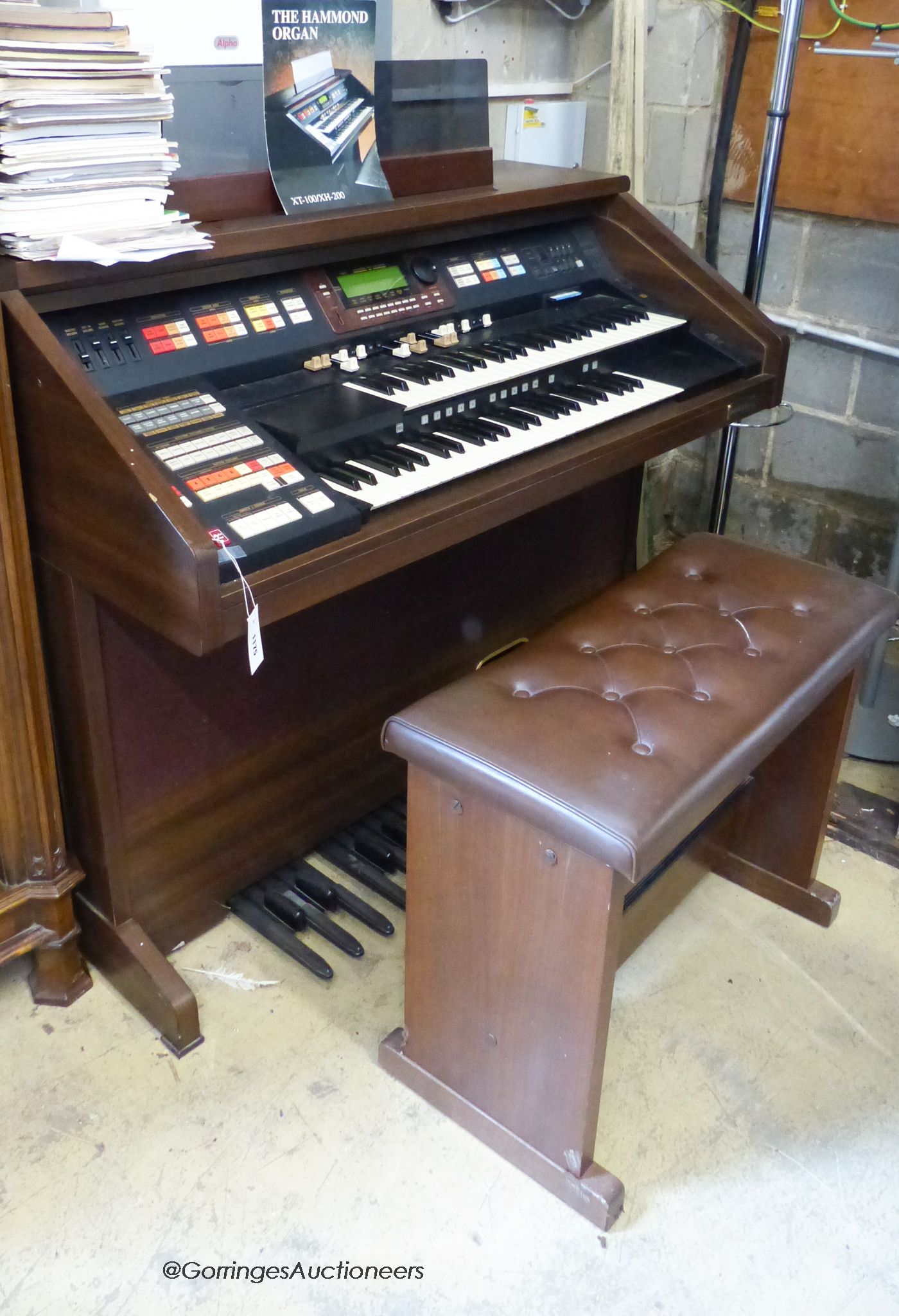 A Hammond organ, XT-100/XH-200 with stool and a quantity of music books. W-125.