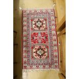 A Kazak style ivory ground rug, 144 x 64cm