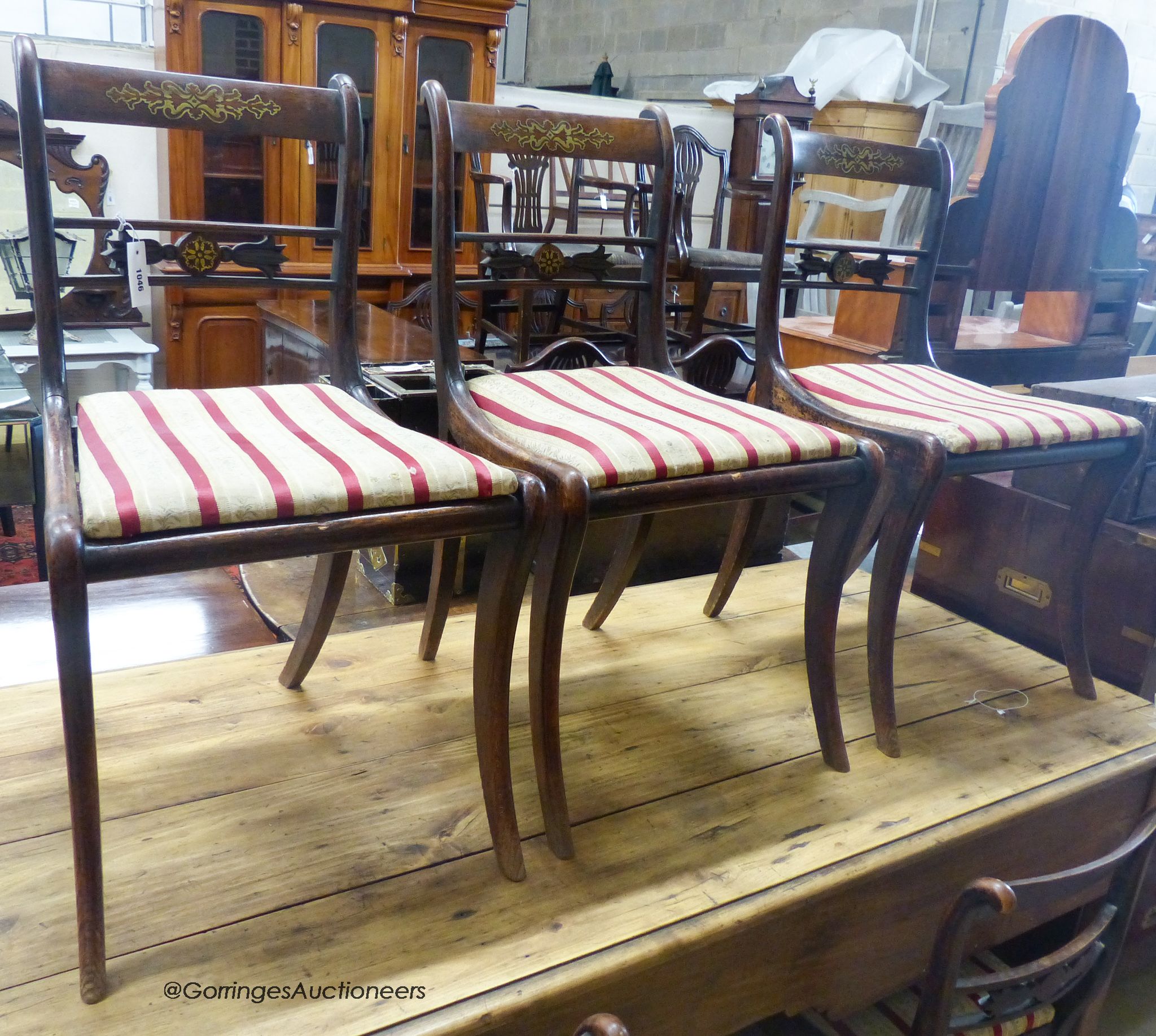 A set of five Regency brass inlaid simulated rosewood cane seated dining chairs