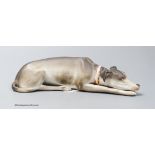 A Continental bisque reclining dog, 17cm
