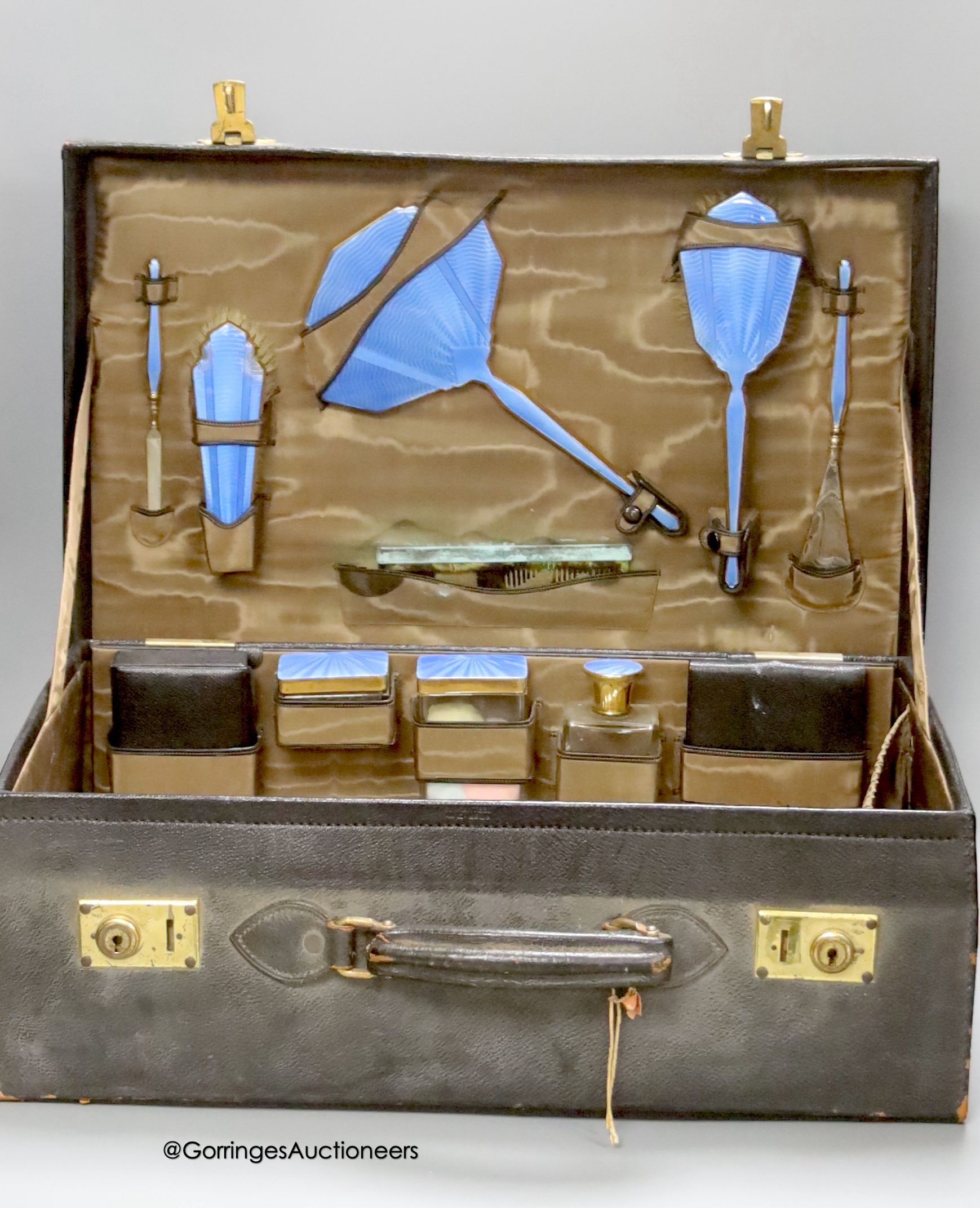 An early 20th century leather vanity case, with enclosed accessories and five further silver