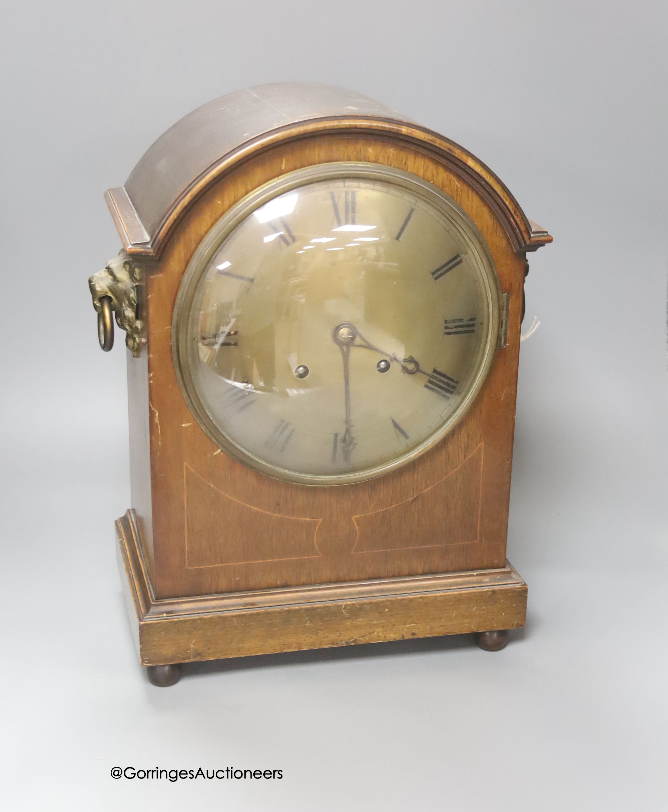 An Edwardian inlaid mahogany mantel clock, with lion mask ring handles, with key and pendulum,