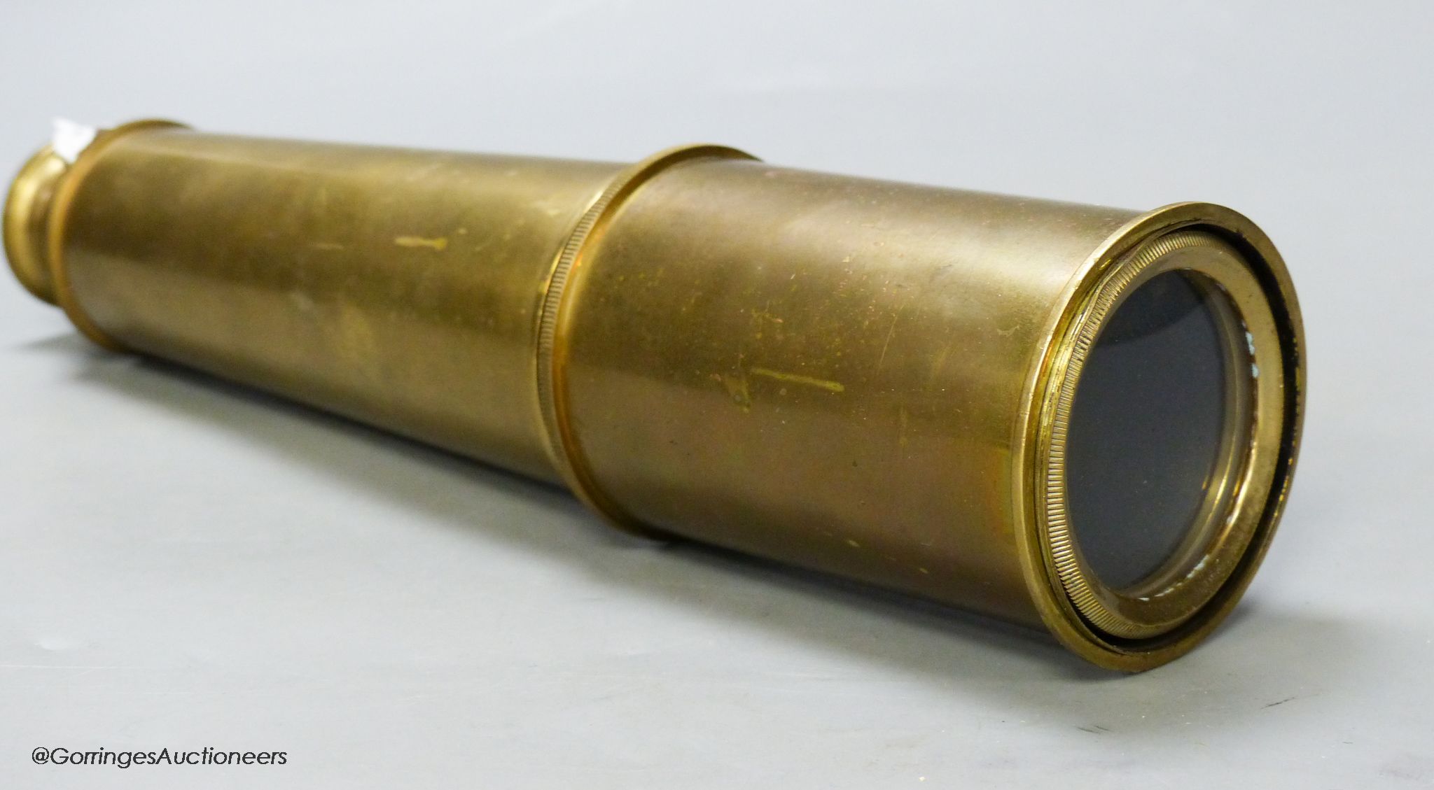 An early 20th century brass three drawer telescope, overall length 90.5cm extended