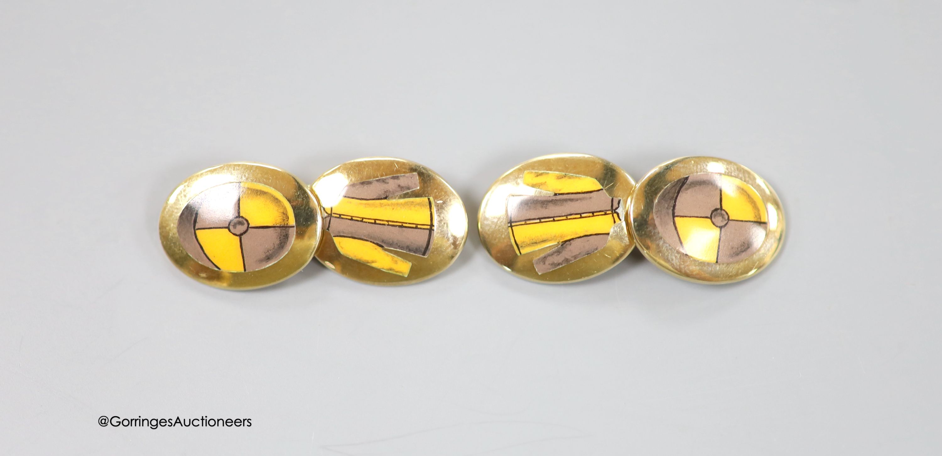 A cased modern pair of silver gilt and enamel Longmire oval cufflinks, decorated with jockey cap
