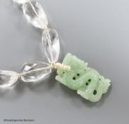 A shaped facet cut rock crystal necklace, with carved jade pendant, seed pearl bale and white metal