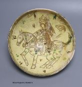An Islamic pottery bowl decorated with a figure on horseback, diameter 23cm (a.f.)