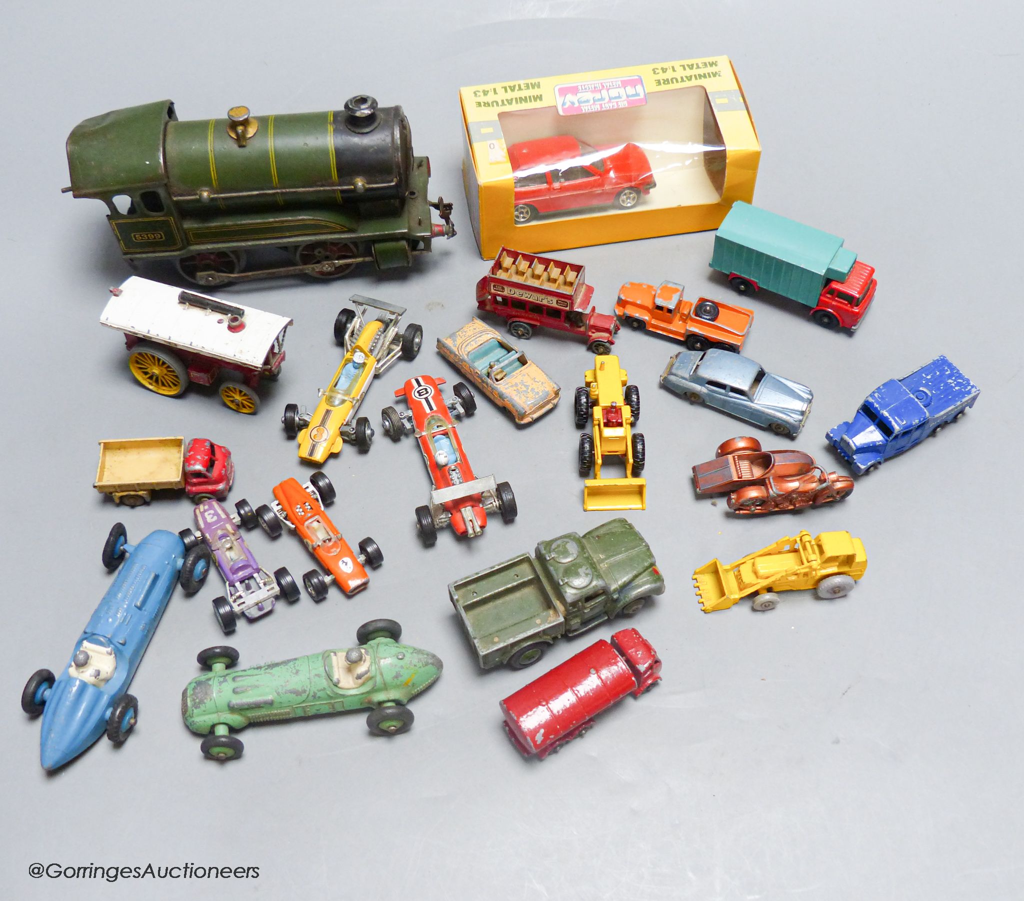 A mixed group of toy cars and an engine (railway)