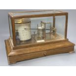 An Edwardian oak barograph retailed by Army & Navy stores ltd. with ink and spare sheets.