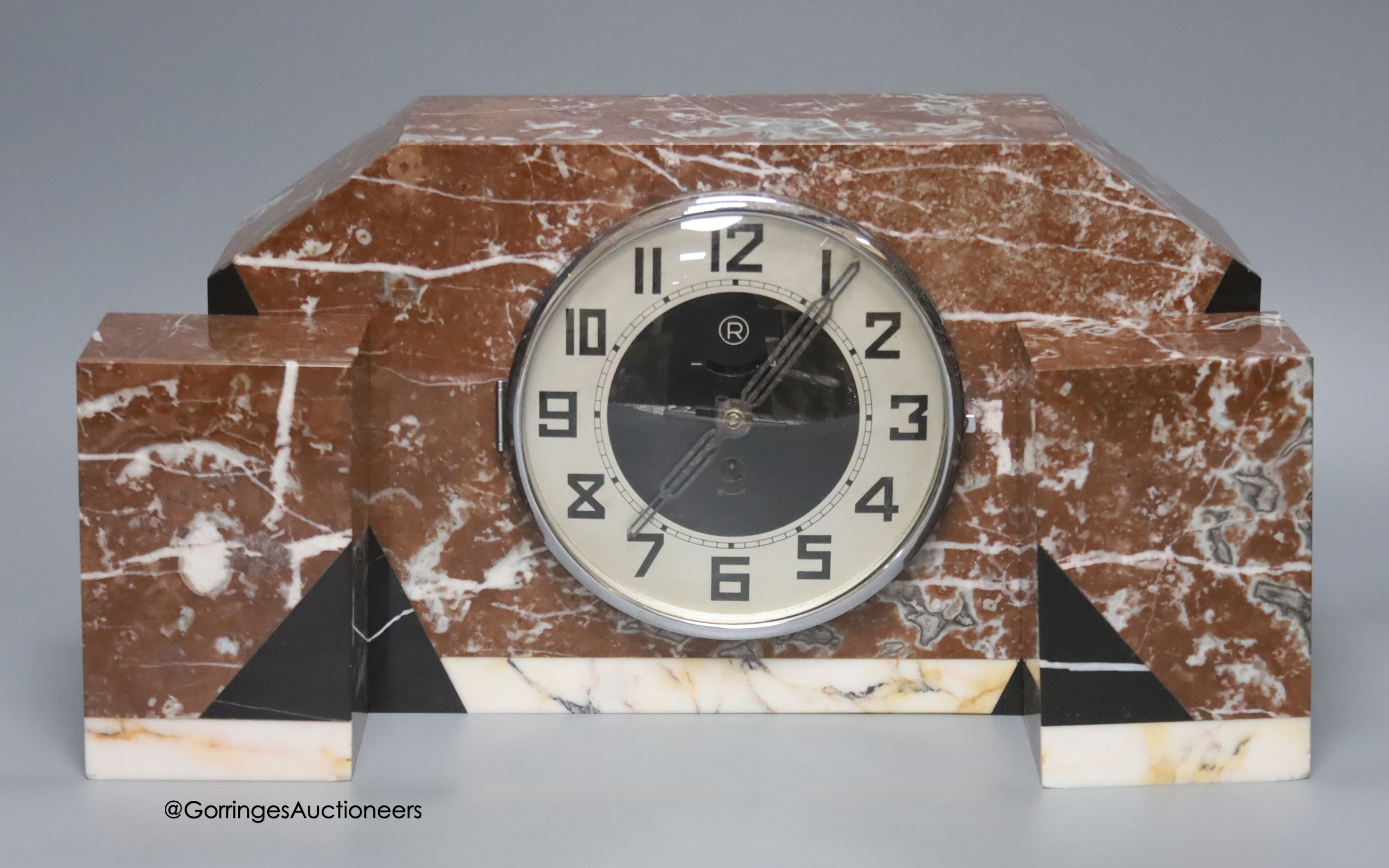 An Art Deco rouge marble clock garniture, length 36cm