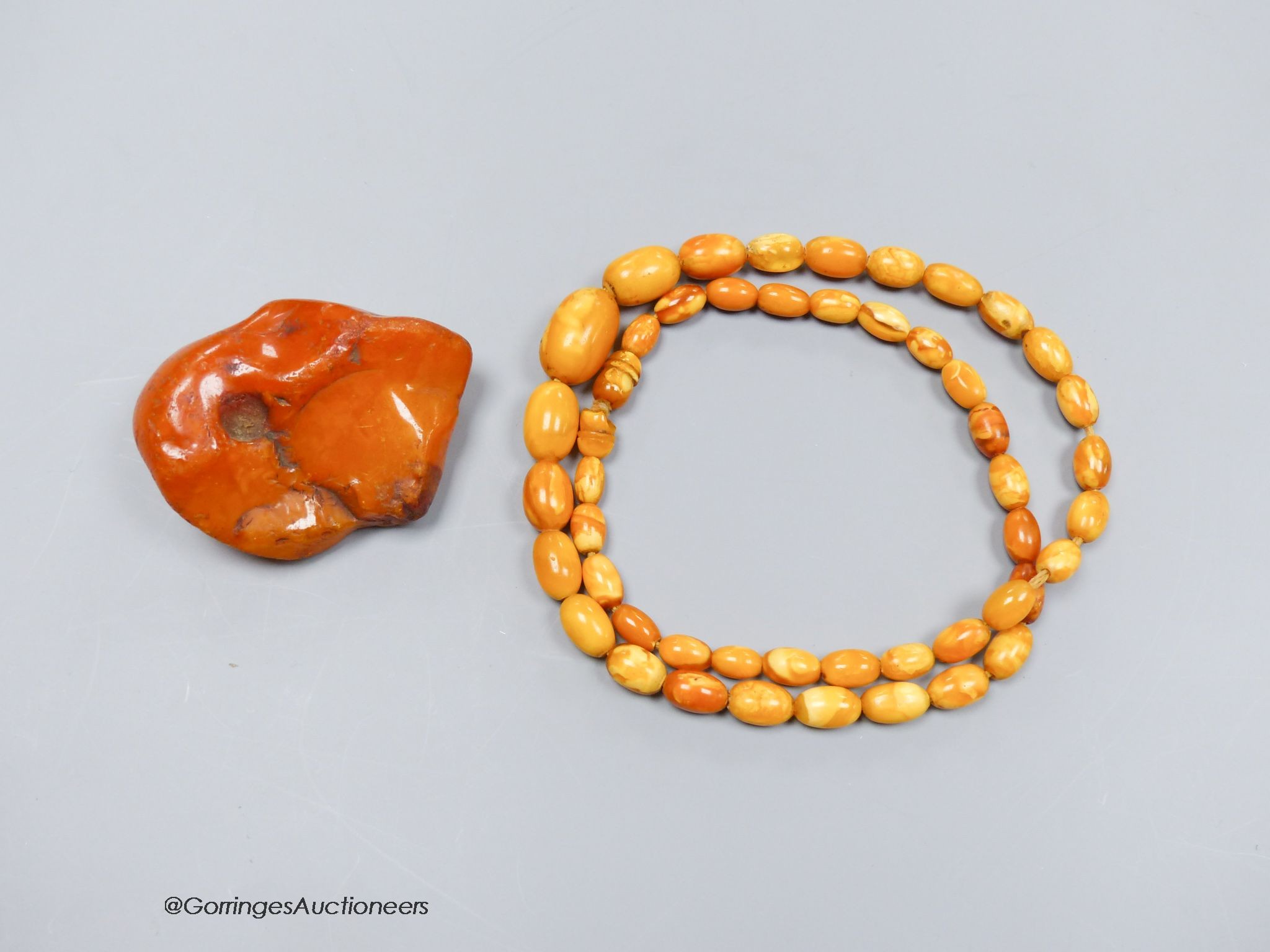 A string of amber beads and a specimen piece of Baltic amber