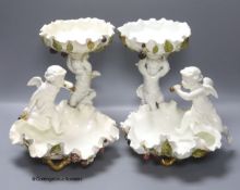 A pair of Moore Bros leaf pattern bowls, encrusted with fruit and surmounted by cherubs and a