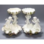 A pair of Moore Bros leaf pattern bowls, encrusted with fruit and surmounted by cherubs and a