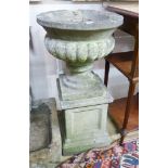 A reconstituted stone campana garden urn on plinth, 40cm diameter, 82cm high