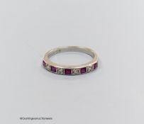 And 18 carat white gold ruby and diamond half eternity ring, size O, gross 2.7g.