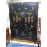 A Tibetan black and polychrome painted two door cabinet, width 115cm, depth 49cm, height 174cm