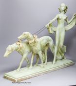 An Art Deco green painted pottery group of a lady and two Borzoi, width 63cm