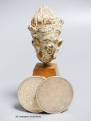 A South East Asian terracotta Buddha's head and two Chinese coins