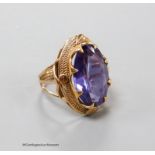 A yellow metal and synthetic colour change sapphire set oval dress ring, size O, gross 8.7 grams.