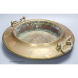 A circular brass two handled bowl, diameter 38cm