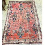 A Caucasian design red ground rug. 224x144cm.