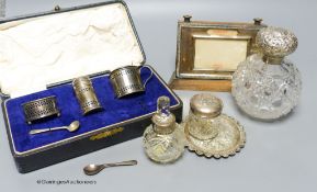 A cased silver condiment set, a silver mounted desk calendar, three mounted glass toilet jars and a