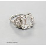 A platinum and emerald cut simulated diamond dress ring, with diamond cluster set shoulders, size