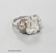 A platinum and emerald cut simulated diamond dress ring, with diamond cluster set shoulders, size