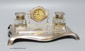 A George V silver desk standish with two silver topped inkwells and central timepiece, Robert