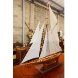 A large single masted model yacht on stand. H-160cm