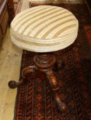 A Victorian walnut revolving piano stool.