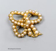 A yellow metal and split pearl set ribbon bow brooch, 30mm, gross weight 6.1 grams.15ct gold seed-